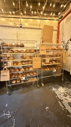 Fresh artisan sourdough loaves on racks in Crave Sourdough bakery